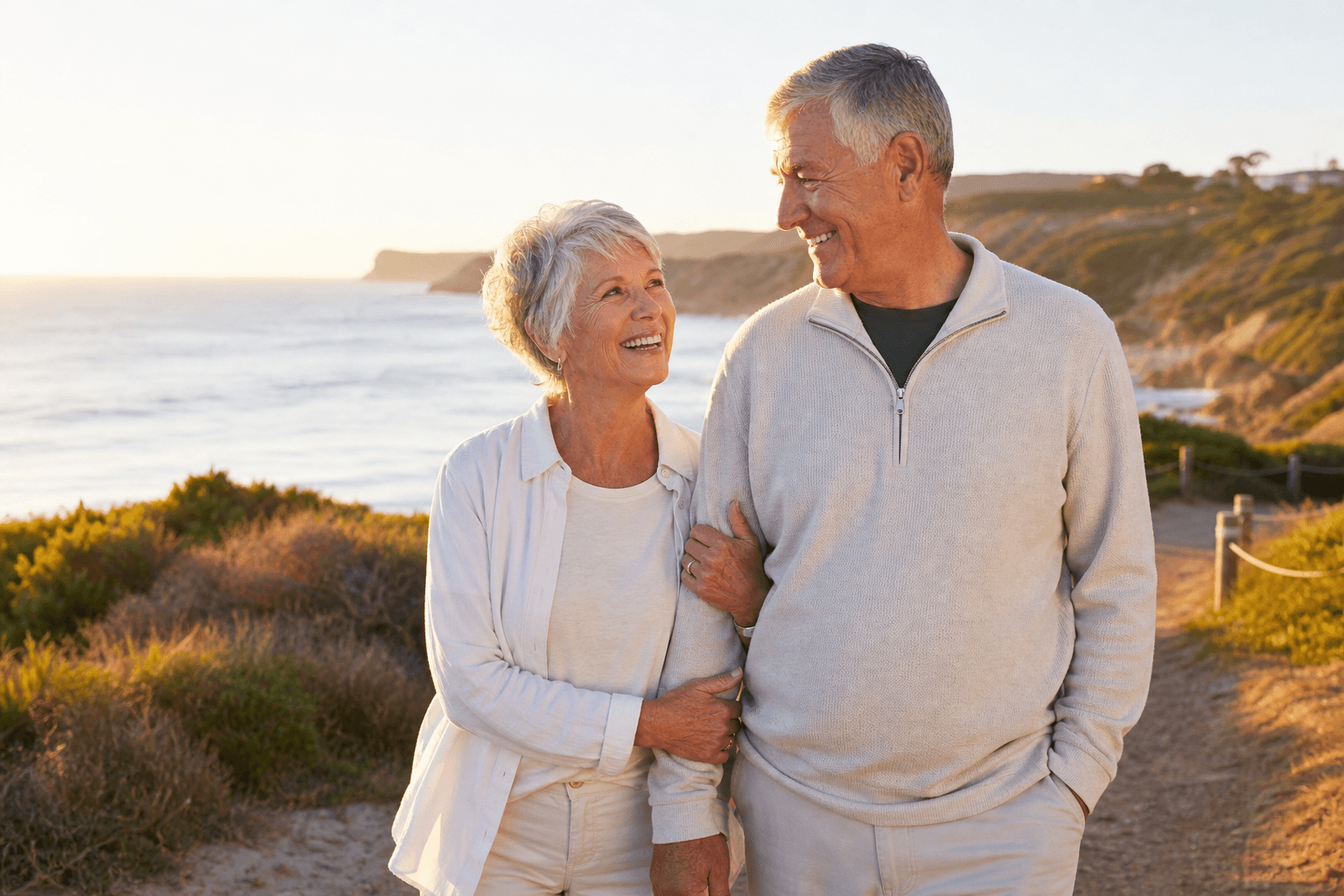 Senior couple enjoying a walk on the beach after recovery